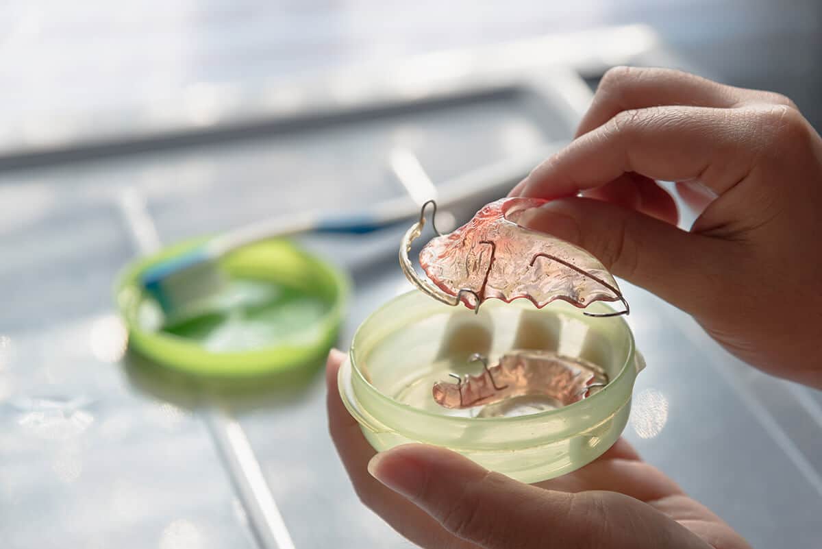 a person inspecting a retainer wondering what are retainers for teeth